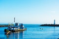 DSC dredge Twin Lakes is dredging harbor channel of Santa Cruz Small Craft Harbor. Breakwater Walton Lighthouse at the harbor exit