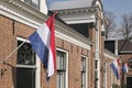 Dutch flags waving in a dutch street on Koningsdag Royalty Free Stock Photo