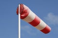 A red and white striped windsock against a blue sky Royalty Free Stock Photo