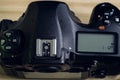 DSLR camera overhead view, second LCD display with settings information on the top, mode dials and hot shoe, close-up photograph