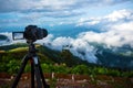 Dslr digital professional camera stand on tripod photographing mountain, Blue sky and cloud landscape.