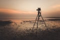 Dslr digital professional camera stand on tripod photographing sea, twilight sky Royalty Free Stock Photo