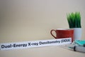 Dual-Energy Xray Densitometry DEXA text, grass pot, coffee cup, syringe, and face green mask. Royalty Free Stock Photo