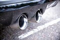 Dual exhaust pipes of a sports car. Silver color with soot from smoke. Close up Royalty Free Stock Photo