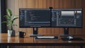 Dual Monitors on Wooden Desk with Coding Screens and Office Essentials Royalty Free Stock Photo