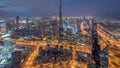 Dubai Downtown skyline futuristic cityscape with many skyscrapers and Burj Khalifa aerial night to day timelapse.