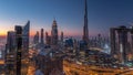 Dubai downtown skyline with tallest skyscrapers and busiest traffic on highway intersection night to day timelapse