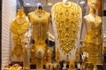 Dubai Gold Souk - golden jewelry - massive golden necklaces, armors, rings and hats displayed in a gold store Royalty Free Stock Photo