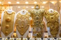 Dubai Gold Souk - golden jewelry - massive golden necklaces, armors, rings and hats displayed in a gold store Royalty Free Stock Photo