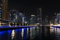 Skyscrapers illuminated by night reflected in water of canal. Dubai marina bay with yachts an boats timelapse hyperlapse Royalty Free Stock Photo