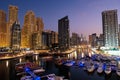 Dubai marina with boats and buildings with gates at night with lights and blue sky Royalty Free Stock Photo