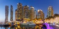 Dubai Marina and Harbour skyline architecture wealth luxury travel with yacht boat at night panorama in United Arab Emirates