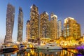 Dubai Marina and Harbour skyline architecture wealth luxury travel with yacht boat at night in United Arab Emirates