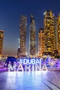 Dubai Marina logo and Harbour skyline architecture wealth luxury travel portrait format at night in United Arab Emirates Royalty Free Stock Photo