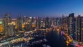 Dubai Marina with yachts in harbor and modern towers from top of skyscraper transition from day to night timelapse Royalty Free Stock Photo