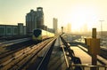 Dubai metro at sunset. Modern subway, car traffic on highway and business buildings. City downtown skyline and railway. Royalty Free Stock Photo