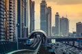 DUBAI, UAE - DECEMBER 16, 2015: Dubai`s downtown architecture in the evening with metro monorail train arriving at the station.