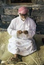 The old man is weaving straw hats to meet guests in the pavilio