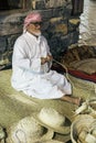 The old man is weaving straw hats to meet guests in the pavilio