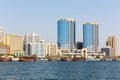 Deira skyline with Rolex Twin Towers and traditional wooden boats Dhows moored on Dubai Creek canal. Royalty Free Stock Photo