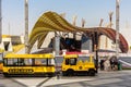 Expo 2020 Dubai - Expo Explorer yellow compressed air train parked in front of Iraq Pavilion.