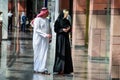 DUBAI, UAE - FEBRUARY 20, 2014: Man and woman on the street in Dubai. Clothing in the United Arab Emirates.