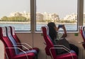 Dubai, UAE - 05.06.2022 - Girl taking a picture with her phone of the Palm Jumeirah view while on water ferry trip. Holiday