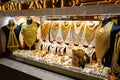 Golden jewelry - massive golden necklaces, armors, rings and hats displayed in a gold store in Dubai Gold Souk, Deira. Royalty Free Stock Photo