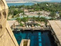 Dubai, UAE - June 3, 2013: Beautiful view of the Aquaventure Waterpark. People relax and sunbathe near the pool among green palm