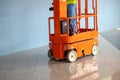 DUBAI, UAE - MARCH 24: Orange hydraulic scissor platform stand by for service and maintenance in work area