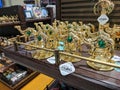 Dubai, UAE - March 02, 2022: Souvenirs in the form of gold-colored camels with green stones are on a shelf in a store for sale to