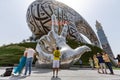 Dubai, UAE - March 28, 2022: Tourists taking photos in front of unique modern exterior of Museum of The Future in Dubai