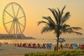 Dubai, UAE - May 08, 2018: Dubai Marina promenade at sunset. Ferris wheel, Dubai marina beach, United Arab Emirates. Marina beach