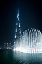 Wonderful evening fountain show in Dubai downtown with famous tower on the background