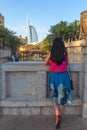 DUBAI, UAE - NOV 12, 2018: view from back of young tourist woman looking at Burj al Arab from Madinat Jumeirah souk.