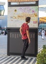 Dubai, UAE - 11.18.2021 - Opportunity district of EXPO 2020. Teenage boy studying map of the venue. Event Royalty Free Stock Photo