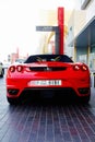 DUBAI, UAE - SEPTEMBER 23, 2012: A red convertible Ferrari car parked outside The Dubai Mall