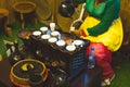 Dubai, UAE - 12th october, 2022: african lady pour traditional coffee to cup from pot. Old coffee preparation methods with vintage