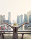 Dubai, UAE - 12th october, 2022: excited tourist girl holds up hands and enjoys the stunning view of the skyscrapers in the Dubai