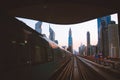 Dubai, UAE - 10th october, 2022: metro arrives to metro stop in city of Dubai with scenic modern buildings panorama background