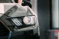Dubai, UAE, United Arab Emirates - May 25, 2021: Close Up of Headlight Of Black Color Ford Mustang Car Parked At Street
