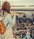 Young woman looking at downtown Dubai from the top of the Burj Khalifa tower,