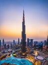 Dubai, United Arab Emirates - July 5, 2019: Burj khalifa rising above Dubai mall and fountain surrounded by modern buildings top Royalty Free Stock Photo