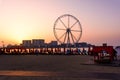 Dubai, United Arab Emirates - March 8, 2018: Sunbeds and romantic sunset at JBR, Jumeira Beach Resort beach with ferris wheel in Royalty Free Stock Photo