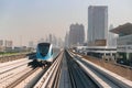 Dubai, United Arab Emirates - November 06, 2021: Dubai metro train on rails at background of skyscrapers. Famous outdoor subway Royalty Free Stock Photo