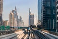 Dubai, United Arab Emirates - November 06, 2021: Dubai metro train on rails at background of skyscrapers. Famous outdoor subway Royalty Free Stock Photo