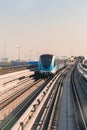 Dubai, United Arab Emirates - November 06, 2021: Dubai metro train on rails at background of skyscrapers. Famous outdoor subway Royalty Free Stock Photo