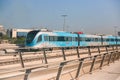 Dubai, United Arab Emirates - November 06, 2021: Dubai metro train on rails at background of skyscrapers. Famous outdoor subway Royalty Free Stock Photo