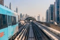 Dubai, United Arab Emirates - November 06, 2021: Dubai metro train on rails at background of skyscrapers. Famous outdoor subway Royalty Free Stock Photo