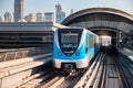 Dubai, United Arab Emirates - November 06, 2021: Dubai metro train on rails at background of skyscrapers. Famous outdoor subway Royalty Free Stock Photo